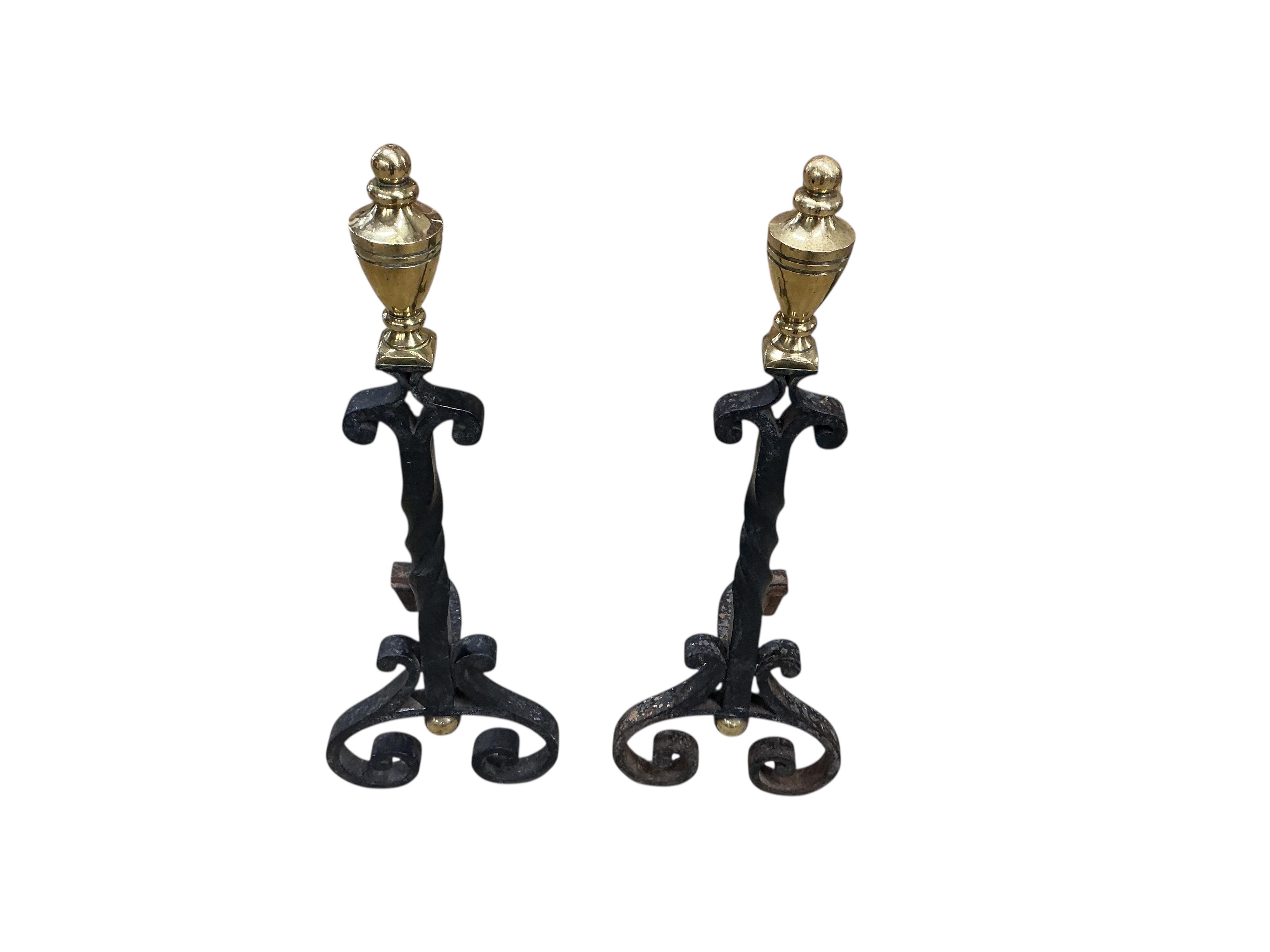 A pair of wrought iron and brass tipped fire dogs together with a black painted iron and wire mesh three fold spark guard and one other spark guard